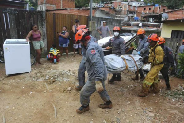 Bombeiros retirando corpo de vítima em São Sebastião (Foto: Reprodução)