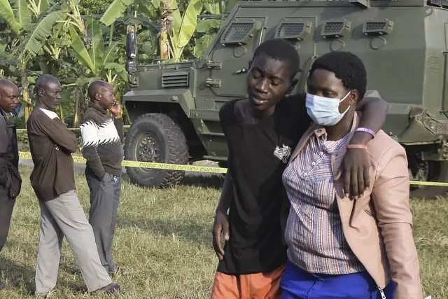 Garoto é consolado após ataque a escola deixar mortos em Mpondwe, em Uganda — Foto: AFP